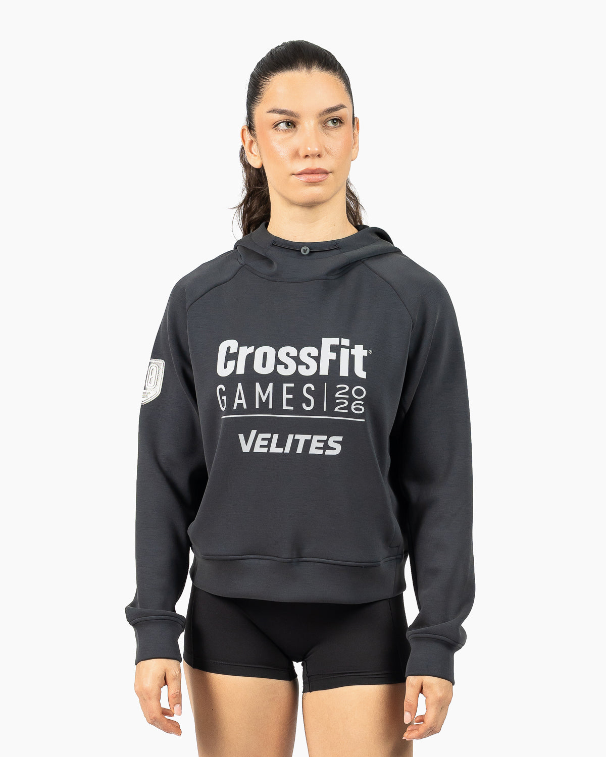 Model wearing the black women's HOLO 20th Anniversary CrossFit Games crop hoodie, three-quarter view